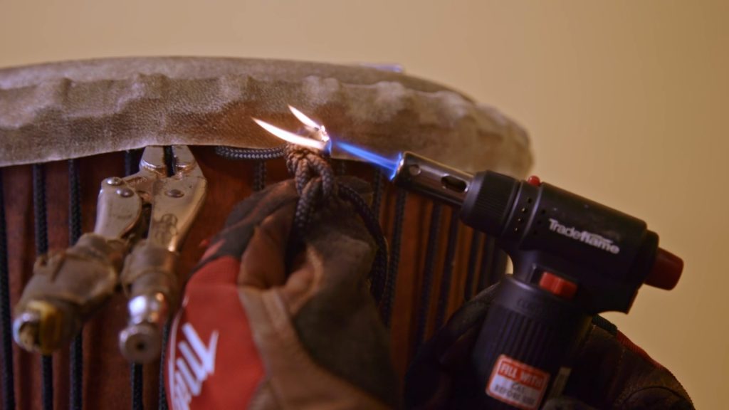 Drum Making Workshop with Elliott Orr at the Torque'n the Drum workshop in Billinudgel. 'Sealing the knot' with Butane Betty. Photo credit Peter Teys.